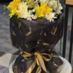 Golden Glow – Sunshine Yellow Gerbera & Rose Bouquet in Midnight Feather Wrap